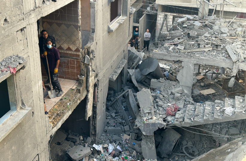  Palestinians inspect the site of an Israeli strike on a house, amid the ongoing conflict between Israel and the Palestinian Islamist group Hamas, in Rafah in the southern Gaza Strip, December 24, 2023. (credit: REUTERS/MOHAMMED SALEM)
