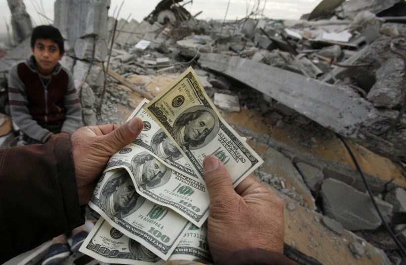  A Palestinian whose house was destroyed during Israel's offensive, shows money distributed by Hamas in Jabalya in the northern Gaza Strip January 28, 2009. (credit: SUHAIB SALEM/REUTERS)
