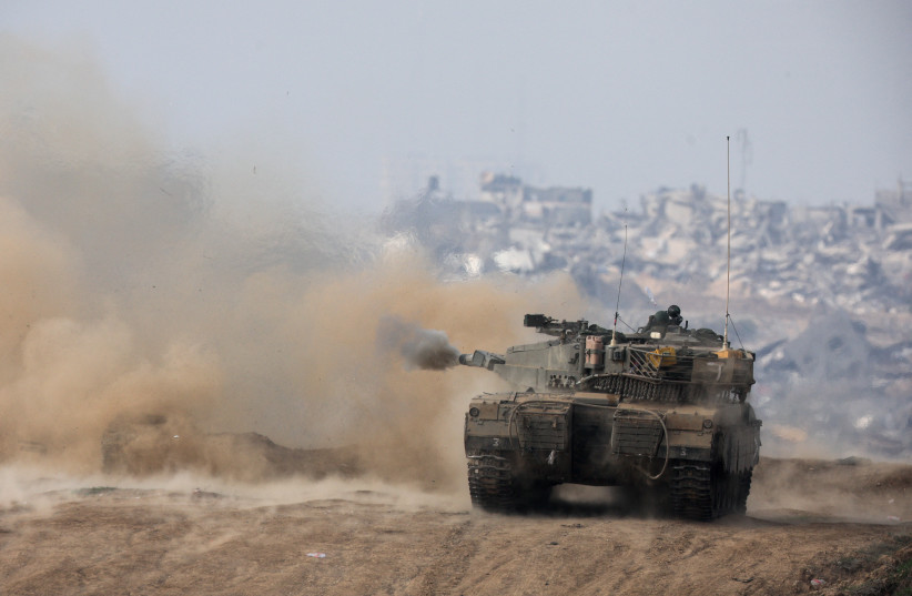  An Israeli tank fires towards Gaza, in southern Israel, December 27, 2023 (credit: AMIR COHEN/REUTERS)
