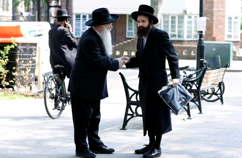  Rabbi Herschel Gluck, President of the Shomrim and Chairman of the Arab-Jewish Forum, shakes hands with a Stamford Hill resident in London, Britain, June 12, 2023 (credit: PETER CZIBORRA/REUTERS)