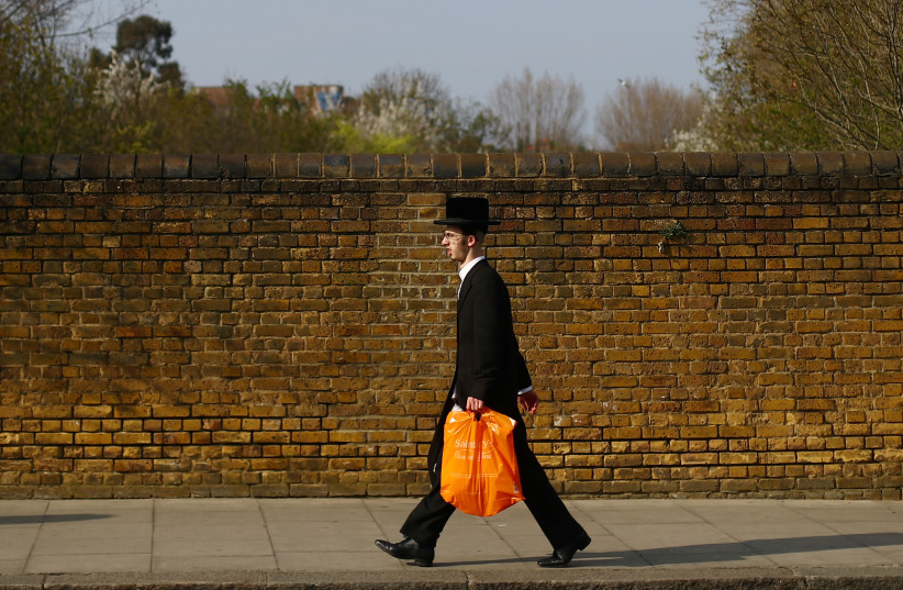  An Orthodox Jewish man is seen in Stamford Hill, as the spread of the coronavirus disease (COVID-19) continues, London, Britain, April 8, 2020. (credit: Hannah McKay/Reuters)