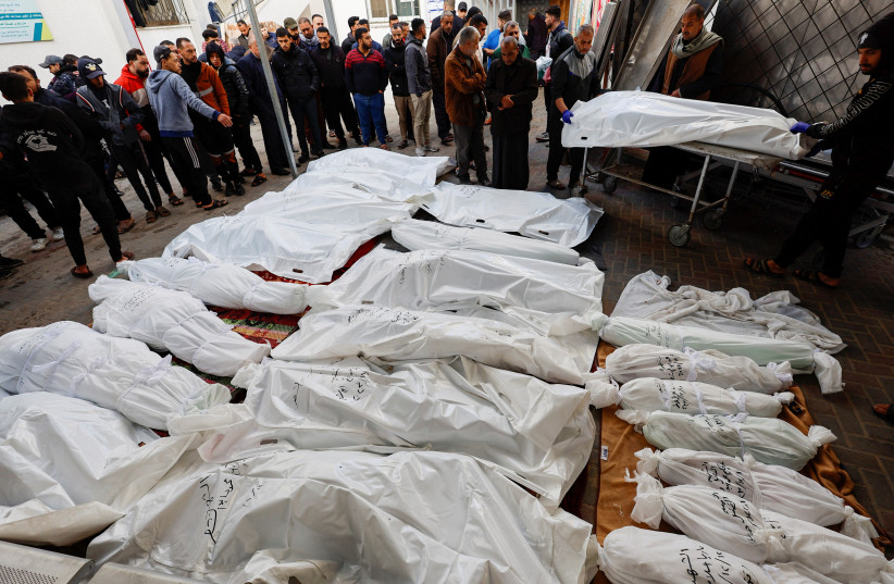  Mourners react next to the bodies of Palestinians killed in Israeli strikes, amid the ongoing conflict between Israel and the Palestinian Islamist group Hamas, at Abu Yossef Al-Najar hospital, in Rafah in the southern Gaza Strip December 12, 2023. (credit: REUTERS)
