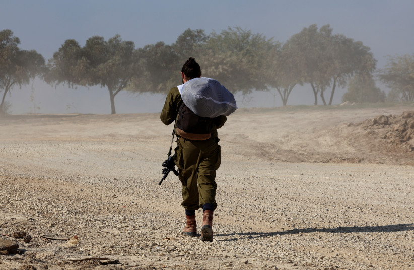  An IDF soldier walks near the Israel-Gaza border, amid the ongoing conflict between Israel and the Palestinian Islamist group Hamas, in southern Israel, December 31, 2023. (credit: Violeta Santos Moura/Reuters)