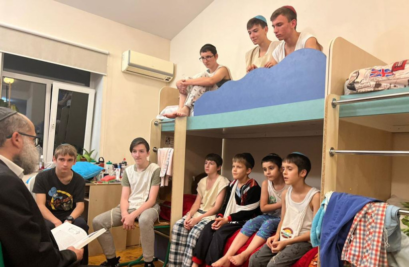 Binyamin Lipkin tells children a story before sleep (Credit: Mishpacha Orphanage Odessa)