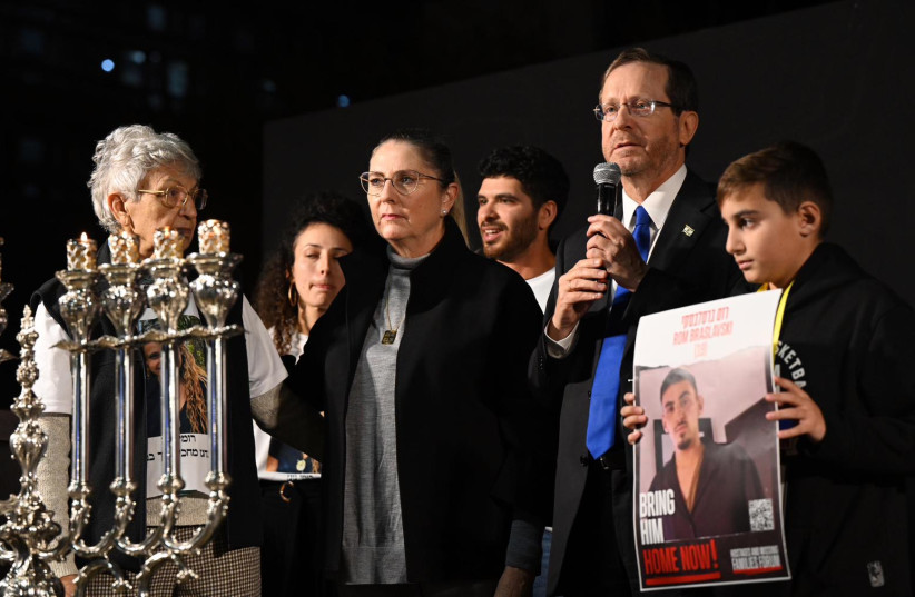  (L-R) Michal Herzog and President Isaac Herzog light Hanukkah candles with family members of people taken hostage in Gaza., at Hostage Square in Jerusalem.  (credit: Courtesy)