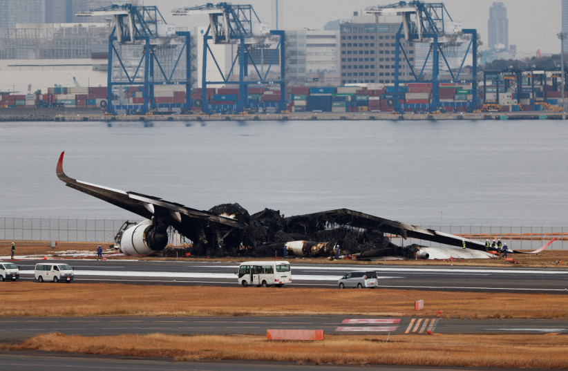  Officials investigate a burnt Japan Airlines (JAL) Airbus A350 plane after a collision with a Japan Coast Guard aircraft at Haneda International Airport in Tokyo, Japan January 3, 2024. (credit: REUTERS/Issei Kato/File Photo)