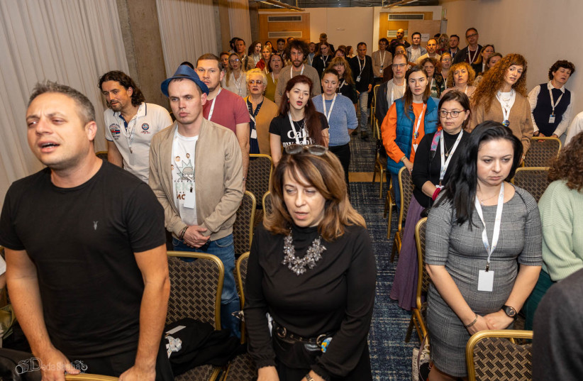  Participants at a Limmud FSU event in Israel amidst the war with Hamas stand for the singing of Hatikvah, Israel's national anthem. (credit: Alexander Khanin via JTA)