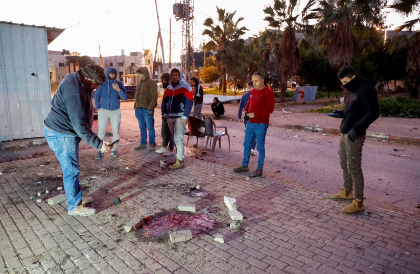 Palestinians check the site where an Israeli air strike killed six men, near Jenin in the West Bank, January 7, 2024. (photo credit: RANEEN SAWAFTA/REUTERS)