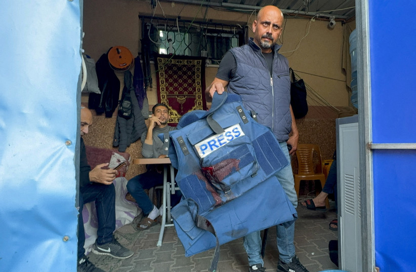  A man holds the flak jacket which belongs to Al Jazeera journalist Wael Al-Dahdouh, who was wounded, amid the ongoing conflict between Israel and the Palestinian Islamist group Hamas, in Khan Younis in the southern Gaza Strip, December 15, 2023.  (credit: REUTERS/BASSAM MASOUD)