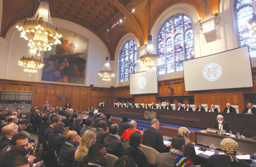  PEOPLE LISTEN to the proceedings inside the ICJ, in The Hague. (credit: THILO SCHMUELGEN/REUTERS)