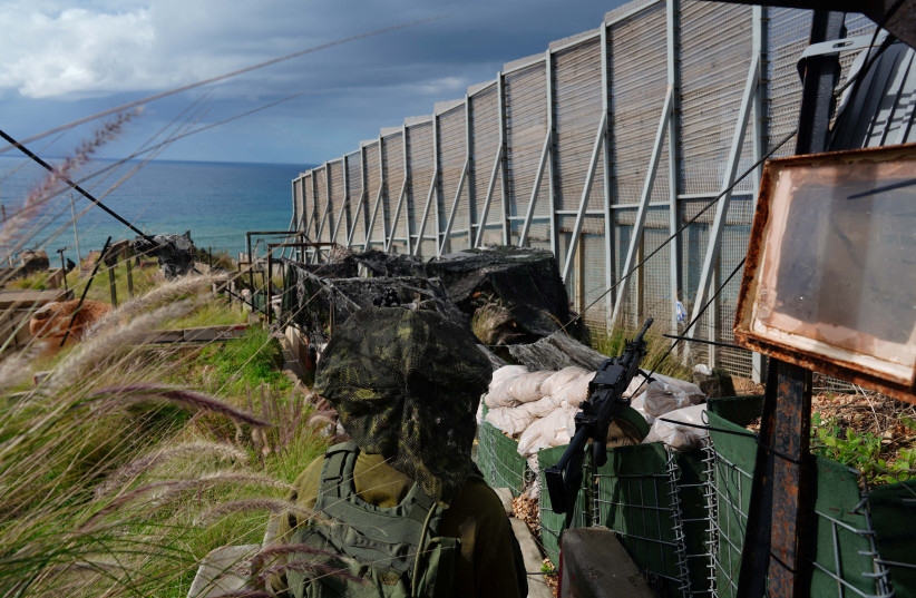  An Israeli soldier stands guard at a fence separating Israel and Lebanon at a military outpost in Kibbutz Hanita, close to the border in northern Israel, January 11, 2024 (credit: ALEXANDRE MENEGHINI/REUTERS)