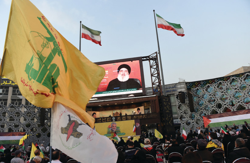  A CROWD in Tehran watches an address, on the screen by Hezbollah leader Hassan Nasrallah, in November. Hezbollah is virtually a state within a state, sucking the lifeblood out of Lebanon at the instigation of Iran, says the writer. (credit: WEST ASIA NEWS AGENCY/REUTERS)