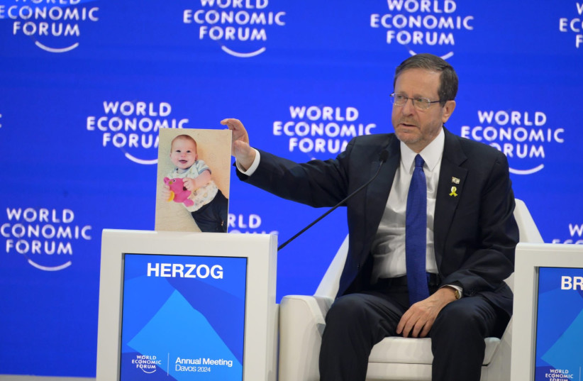  Israeli President Isaac Herzog shows a photo of the toddler Kfir Bibas, the youngest hostage still held by Hamas. (credit: AMOS BEN GERSHOM/GPO)