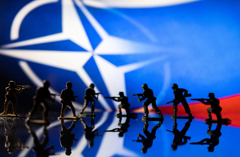  Army soldier figurines are displayed in front of the NATO logo and Russian flag colours background in this illustration taken, February 13, 2022. (credit: REUTERS/DADO RUVIC/ILLUSTRATION)