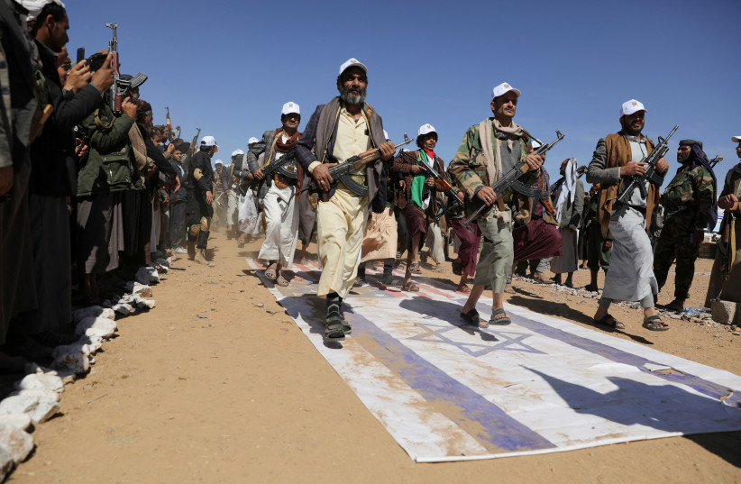  Tribesmen loyal to the Houthis march on U.S. and Israeli flags during a military parade for new tribal recruits amid escalating tensions with the U.S.-led coalition in the Red Sea, in Bani Hushaish, Yemen January 22, 2024. (credit: KHALED ABDULLAH/REUTERS)