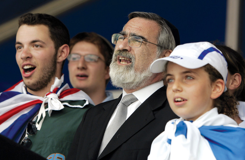  Sir Jonathan Sacks, then-Britain's chief rabbi, sings a prayer at a rally of British Jews in solidarity with Israel at the Jewish Free School in Kenton, northwest London, in 2006. (credit: PAUL HACKETT/REUTERS)