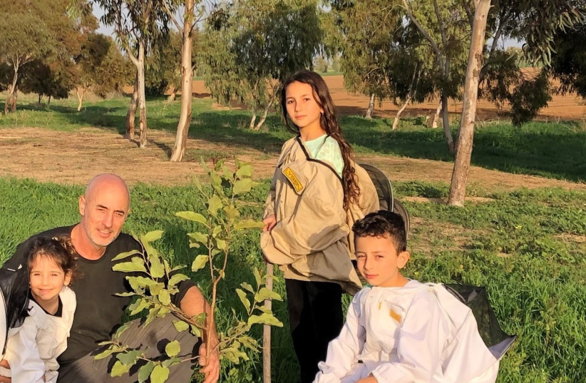  Beekeeper Ido Shahar and his children, from Moshav Kalhim and his children Be'eri (4), Zohar (7) and Carmel (9) planting in the agricultural areas of the Gaza border communities. (credit: Ido's Honey, Klahim)