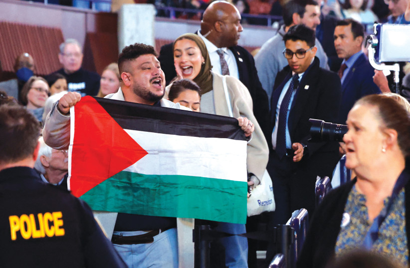  A PROTESTER holds a Palestinian flag as US President Joe Biden attends a presidential election campaign event in Manassas, Virginia, last week. The Palestinian flag has been featured at rallies, protests, and riots all over the world since the Palestinian massacre of innocent Jews on October 7. (credit: EVELYN HOCKSTEIN/REUTERS)