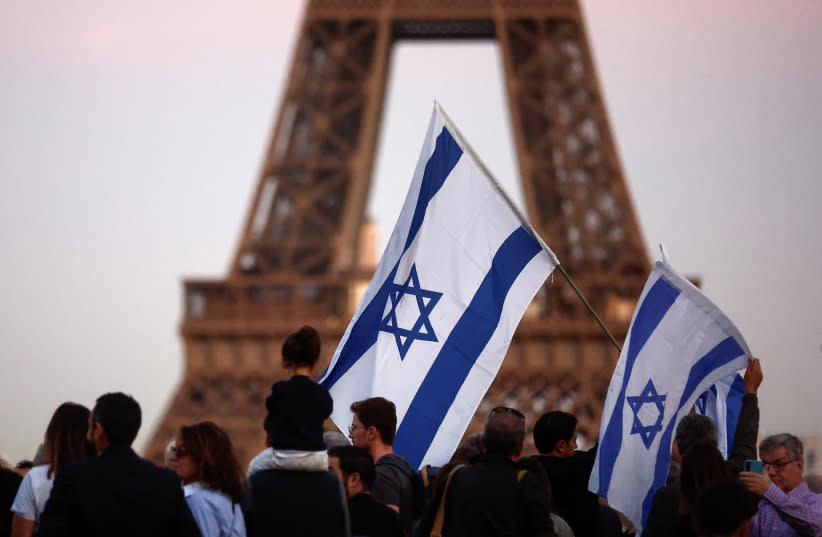  Partidarios de Israel sostienen banderas mientras protestan, tras el mayor ataque de Hamás contra Israel en años, en París, Francia, 9 de octubre de 2023 (credit: REUTERS/BENOIT TESSIER)