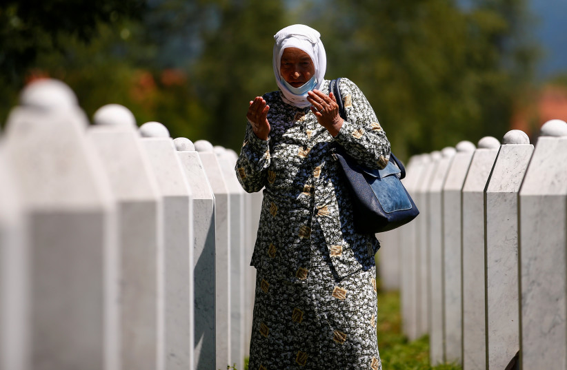  A woman prays next to the graves at Potocari-Srebrenica Memorial, in Potocari, near Srebrenica, Bosnia And Herzegovina July 10, 2020 (credit: REUTERS/DADO RUVIC)