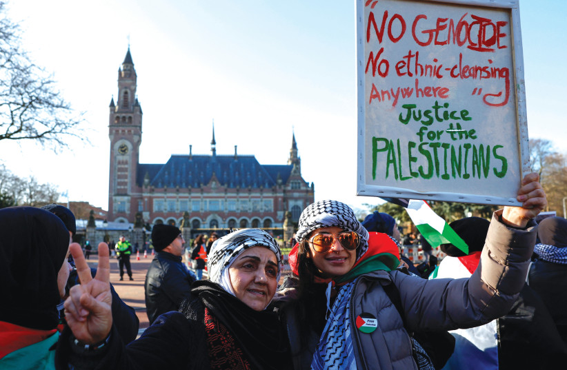  PRO-PALESTINIAN protesters pose for a photo in front of the International Court of Justice in The Hague, last Friday. ‘The ICJ has handed Israel, however unintentional it may be, a golden public relations ticket that it so desperately needs,’ the writer argues.  (credit: PIROSCHKA VAN DE WOUW/REUTERS)