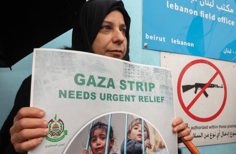  A Palestinian woman holds a placard during a protest against the suspension of UNRWA funding by some Western states, in front of the United Nations Palestinian aid agency UNRWA's building in Beirut, Lebanon January 30, 2024. (credit: REUTERS/MOHAMED AZAKIR)