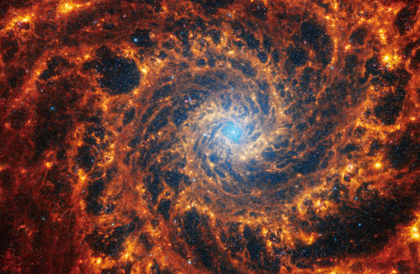  Spiral galaxy NGC 628, located 32 million light-years away from Earth, is seen in an undated image from the James Webb Space Telescope. Webb’s image of NGC 628 shows a densely populated face-on spiral galaxy anchored by its central region, which has a light blue haze that takes up about a quarter o (credit: VIA REUTERS)