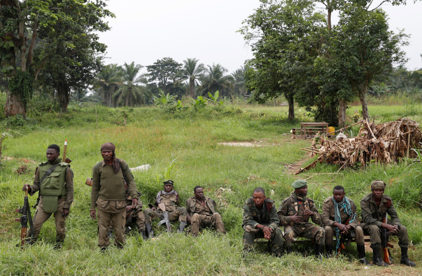  Armed Forces of the Democratic Republic of the Congo (FARDC) soldiers rest next to a road after Islamist rebel group called the Allied Democratic Forces (ADF) attacked area around Mukoko village, North Kivu province of Democratic Republic of Congo, December 11, 2018. (credit: GORAN TOMASEVIC/REUTERS)