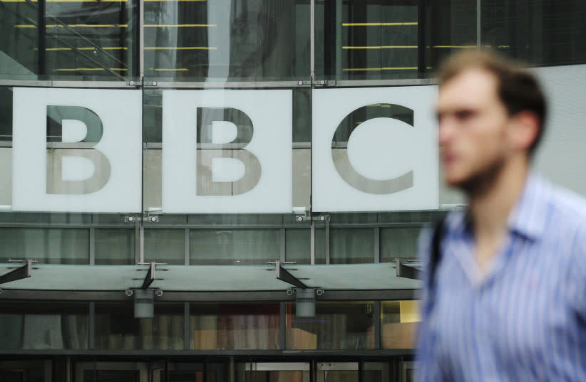   ChatGPT Un peatón camina frente a un logo de la BBC en Broadcasting House en el centro de Londres. (credit: OLIVIA HARRIS/ REUTERS)