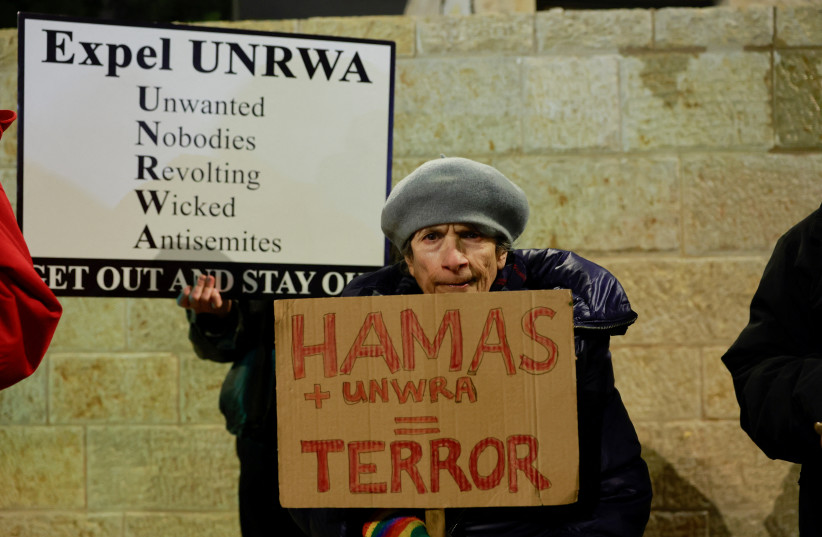  Israeli protesters hold placards as they demonstrate outside the UNRWA offices, amid the ongoing conflict between Israel and Hamas, in Jerusalem February 5, 2024 (credit: AMMAR AWAD/REUTERS)
