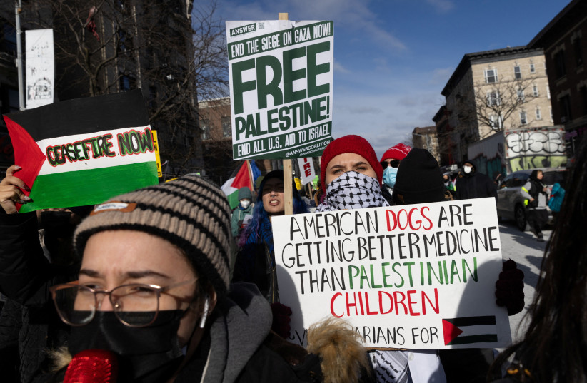  Pro-Palestinian demonstrators hold signs as they take part in the ''Biden: stop supporting genocide!'' rally in New York City, U.S., January 20, 2024 (credit: JEENAH MOON/REUTERS)