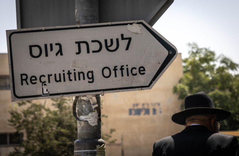  Ultra-Orthodox Jews walk outside the army recrutiment office in Jerusalem, August 16, 2023 (credit: Chaim Goldberg/Flash90)