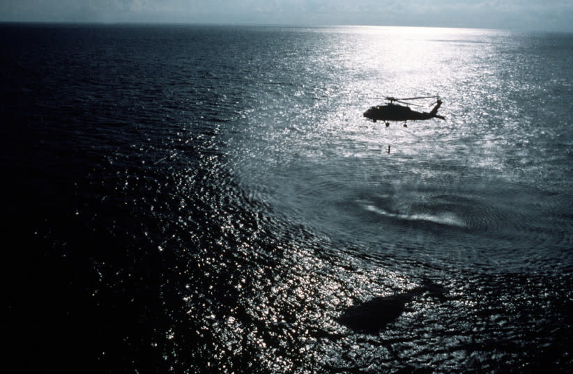  Un helicóptero sobrevuela el mar de noche (Ilustrativo) (credit:  NARA & DVIDS Public Domain Archive)