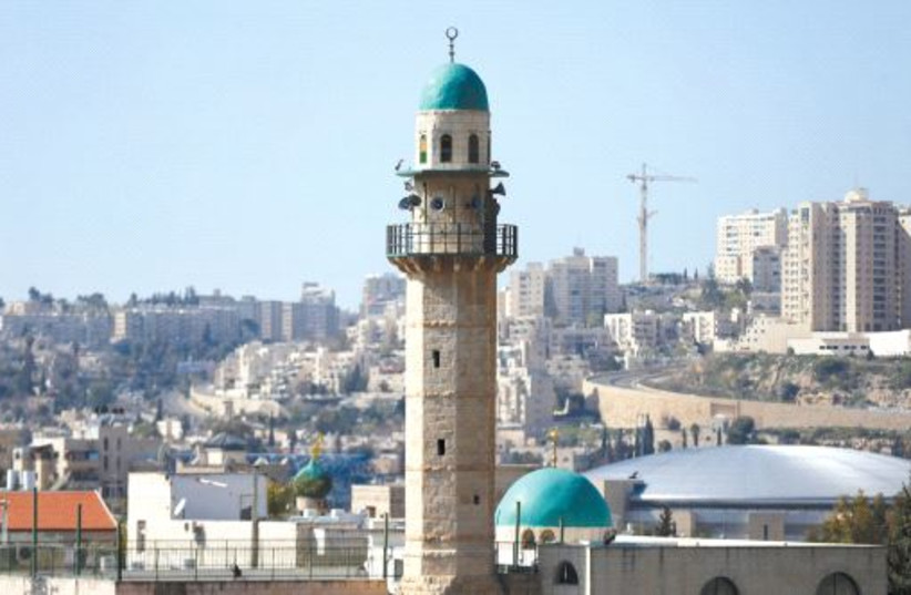 Se ve la torre de una mezquita en el barrio árabe de Beit Safafa en Jerusalem (credit: REUTERS)