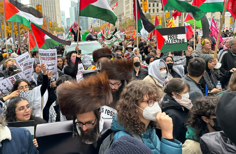  Manifestantes ondean banderas palestinas frente al Consulado de Estados Unidos en Toronto el mes pasado. Entre los manifestantes se encuentran los miembros de la secta judía anti-Israel Neturei Karta. (credit: Kyaw Soe Oo/Reuters)