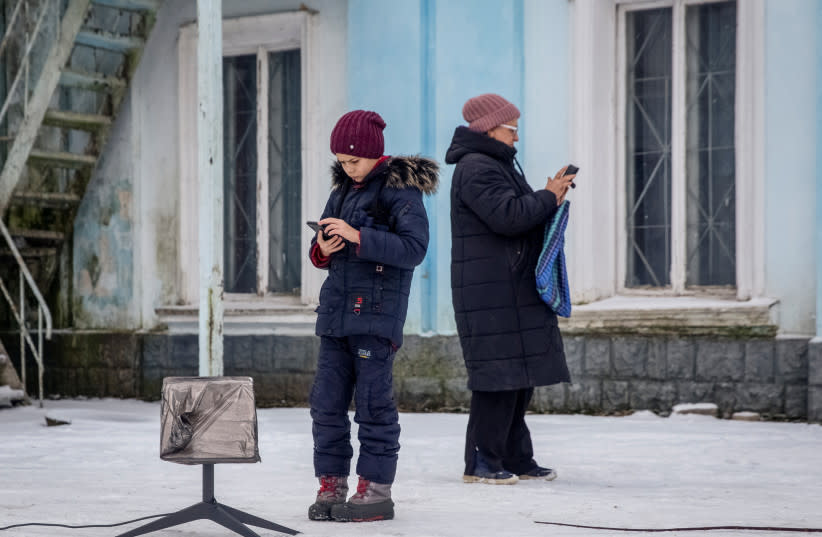  Residentes locales utilizan una terminal Starlink en medio del ataque de Rusia a Ucrania, en Chasiv Yar, región de Donetsk, Ucrania, 31 de enero de 2023. (credit: REUTERS/OLEKSANDR RATUSHNIAK)
