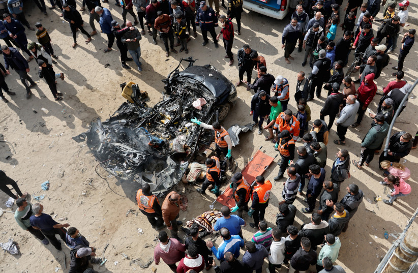  Palestinians inspect a car hit by an Israeli strike, amid the ongoing conflict between Israel and Palestinian Islamist group Hamas, in Rafah in the southern Gaza Strip, February 10, 2024. (credit: REUTERS/IBRAHEEM ABU MUSTAFA)