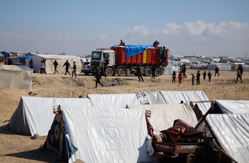  A truck carrying aid arrives at a tent camp, as Displaced Palestinians who fled their houses due to Israeli strikes, take shelter there amid the ongoing conflict between Israel and Hamas, near the border with Egypt in Rafah in the southern Gaza Strip, February 6, 2024. (credit: REUTERS/MOHAMMED SALEM)