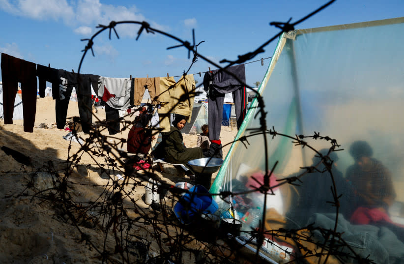  Miembros desplazados de la familia palestina Abu Mustafa, que huyeron de su casa debido a los ataques israelíes, se refugian en la frontera con Egipto, en Rafah, en el sur de la Franja de Gaza, 10 de febrero de 2024. (credit: REUTERS/MOHAMMED SALEM)