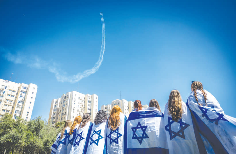 Personas observan el espectáculo aéreo militar que forma parte de las celebraciones del 75º Día de la Independencia de Israel, desde el Parque Sacher de Jerusalém. (credit: YONATAN SINDEL/FLASH90)