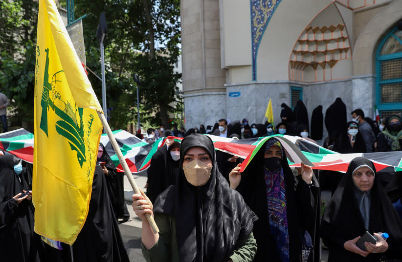  Una mujer iraní sostiene una bandera de Hezbolá durante una protesta para expresar su solidaridad con el pueblo palestino en medio de un recrudecimiento de la violencia entre israelíes y palestinos, en Teherán, Irán, 18 de mayo de 2021. (credit: MAJID ASGARIPOUR/WANA (WEST ASIA NEWS AGENCY) VIA REUTERS)