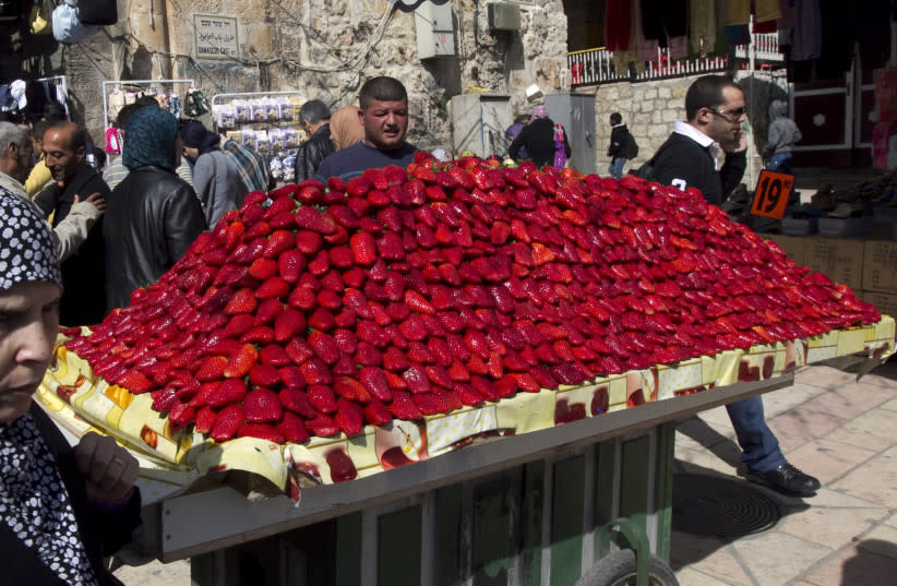  Un vendedor se encuentra detrás de un carrito mientras vende fresas en un mercado en la Ciudad Vieja de Jerusalem (credit: RONEN ZVULUN/REUTERS)