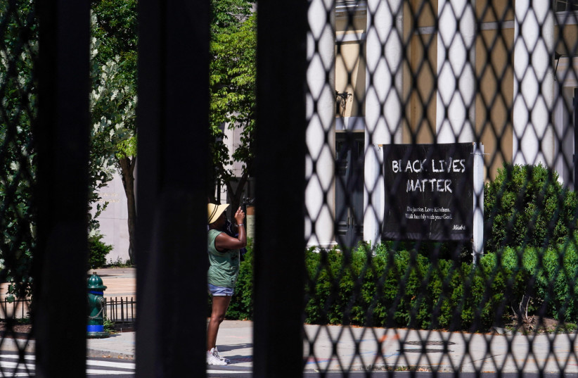  A woman takes a photo of the Black Lives Matter sign posted outside of St. John's Episcopal Church in Black Lives Matter Plaza in Washington, US, June 6, 2021 (credit: REUTERS/SARAH SILBIGER)