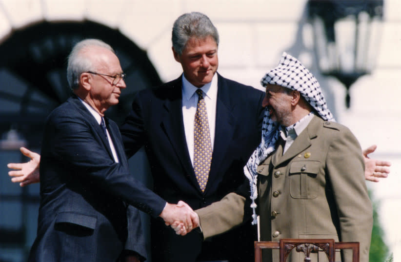  EN SEPTIEMBRE DE 1993, Yasser Arafat, entonces jefe de la OLP, aceptó una nueva división de Cisjordania. Aquí se le ve estrechando la mano del entonces primer ministro Yitzhak Rabin en la ceremonia de la Casa Blanca, ante la mirada del entonces presidente estadounidense Bill Clinton. (credit: GARY HERSHORN/REUTERS)