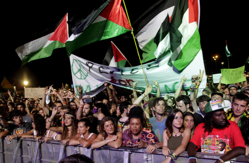 Palestinian flags fly as U.S. Jewish musician Matisyahu performs on stage during the Rototom Sunsplash festival in Benicassim, August 23, 2015. The Spanish reggae festival, bowing to an international outcry, on Wednesday reversed its decision to cancel an invitation to Matisyahu because he had faile (credit: HEINO KALIS / REUTERS)