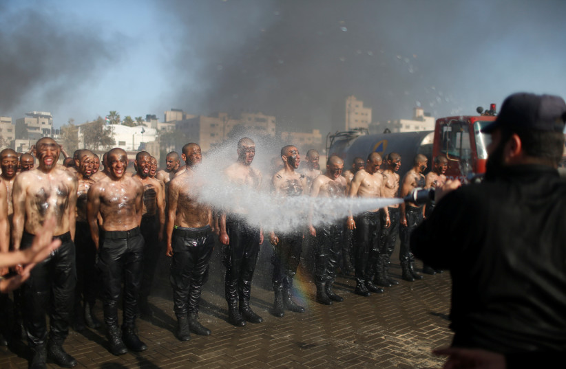  Palestinian police recruits loyal to Hamas are sprayed with water as they demonstrate their skills during a training session at a police academy in Gaza City January 30, 2020. (credit: MOHAMMED SALEM/REUTERS)