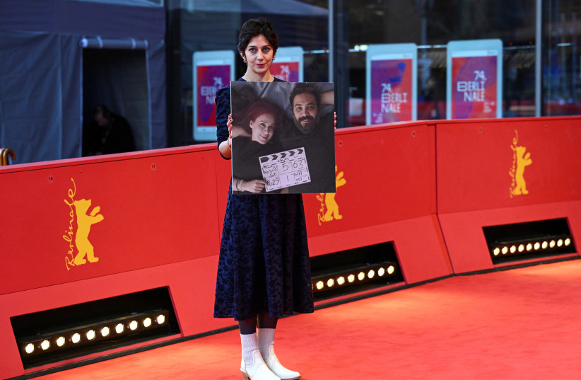  A guest poses with a picture of directors Maryam Moghaddam and Behtash Sanaeeha on the day of the screening of the movie ''My Favourite Cake'' (''Keyke mahboobe man'') at the 74th Berlinale International Film Festival in Berlin, Germany February 16, 2024. (credit: REUTERS/ANNEGRET HILSE)