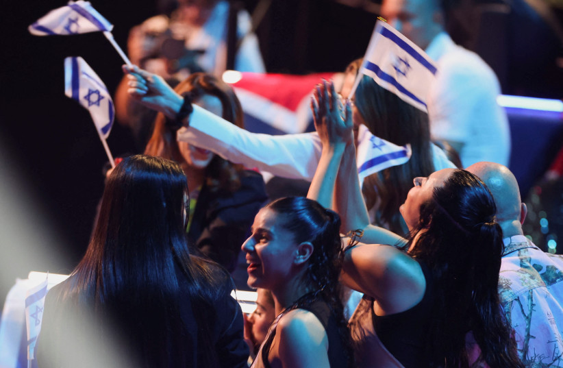 People wave Israeli flags as the jury voting process is held during the grand final of the 2023 Eurovision Song Contest in Liverpool, Britain, May 13, 2023.  (credit: PHIL NOBLE/REUTERS)