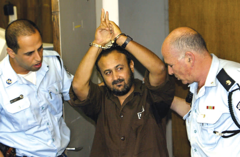  MARWAN BARGHOUTI es conducido al tribunal por la policía para la vista de su juicio en mayo de 2004, en la que fue condenado por cinco cargos de asesinato en atentados terroristas. (credit: David Silverman/Reuters)