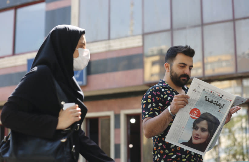  Un HOMBRE ve un periódico con la foto de portada de Mahsa Amini, en Teherán, la semana pasada. (credit: WEST ASIA NEWS AGENCY/REUTERS)